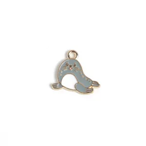 Primer plano de un bonito colgante de metal esmaltado de león marino para collares de bricolaje.