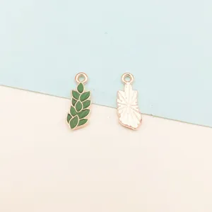 Closeup of two metal enamel plant charms, green leaf and outline pendants for DIY jewelry making.