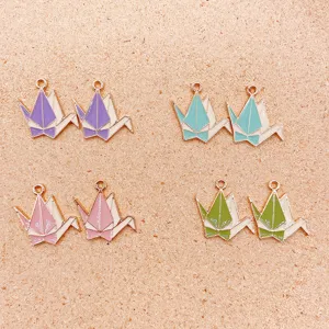 Detailed view of enamel origami crane metal pendants for DIY bracelet necklace making.