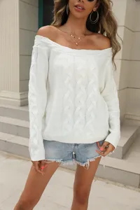 Detailed view of the stylish off-the-shoulder cable knit white sweater texture and cuffs.