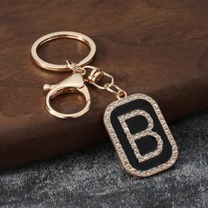 Close-up of a stylish gold-tone letter B keychain with rhinestones and black enamel accent.