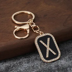 Detail view of the creative gold rhinestone letter X keychain pendant for bag accessory.