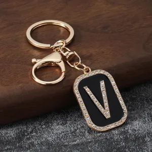 Gold metal rhinestone letter V keychain detail, stylish bag charm and car key ring accessory.