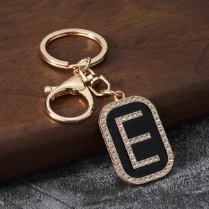 Rhinestone letter E metal keychain pendant, stylish car key ring and bag accessory detail.