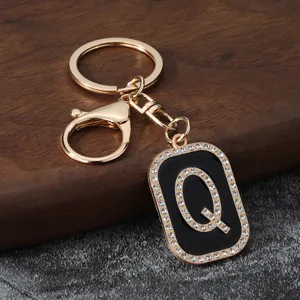 Detailed view of gold rhinestone letter Q keychain pendant, stylish metal car key accessory.
