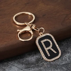 Close-up view of the sparkling rhinestone letter R pendant on a stylish gold keychain.