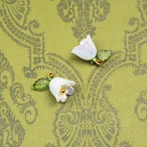 Détail de pendentif fleur de muguet perlé exquis, avec une feuille verte et un anneau doré.