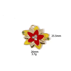 Close-up detail of Christmas flower alloy pendant charm with red enamel and stones.