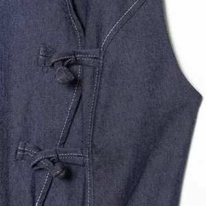 Detail van donkerblauwe denim met traditionele Chinese knopen en contrasterende stiksels.