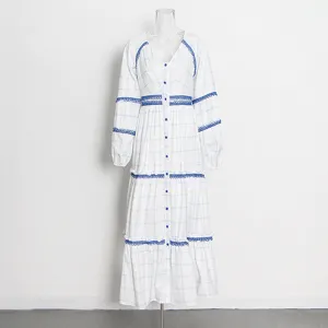 Primer plano del vestido blanco de manga larga con estampado de cuadros y encaje.