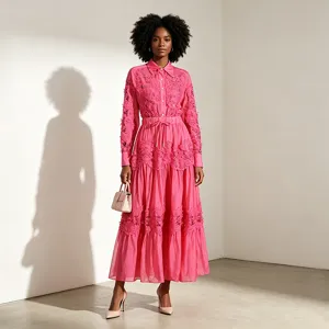 Conjunto de camisa de encaje rosa y falda de capas, mostrando detalles de bordado hueco.