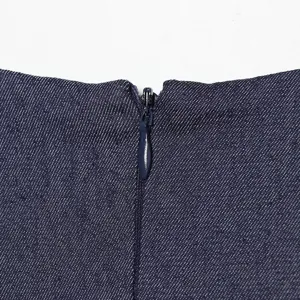 Close-up detail van donkerblauwe denim stof met nette verborgen ritssluiting en stiksels.
