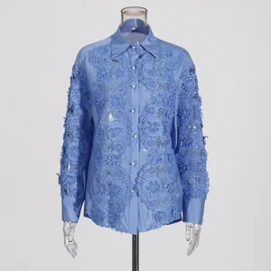 Vista detallada de la camisa azul de manga larga con encaje floral y bordados elegantes.