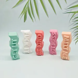 Detailed view of colorful wavy pillar scented candles featuring embossed English phrases.