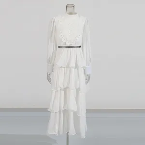 Robe longue blanche à manches longues avec broderie en dentelle et fine ceinture élégante.