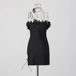 Vista detallada del minivestido negro con volantes florales 3D, cuello halter y abertura lateral.