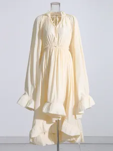 Robe midi vintage à manches longues avec taille cintrée et bas à volants plissés élégants.