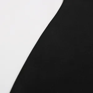 Primer plano detallado del tejido del vestido negro, textura suave y diseño moderno.