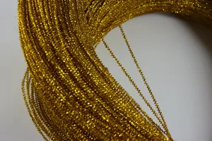 Gold tinsel wire close-up shiny metallic cord detail view for DIY crafts and handmade accessories