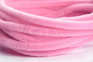 Gros plan détail de tiges chenille artisanales roses, cure-pipes duveteux ultra-denses faits main.