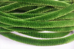 Gros plan detail de tiges chenille artisanales duveteuses vertes, texture velours pour projets DIY.