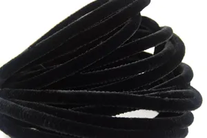 Gros plan de cure-pipe en velours noir, matériel chenille dense pour art artisanal DIY.