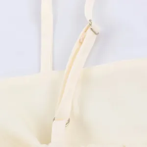 Close-up detail of women camisole shoulder strap with metal adjuster buckle in cream color.