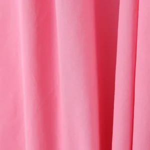 Nahaufnahme der weichen rosa Stofftextur mit eleganten Falten, feines Kleidmaterial.
