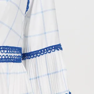 Detalle de vestido largo a cuadros azules y blancos con delicado encaje de ganchillo.