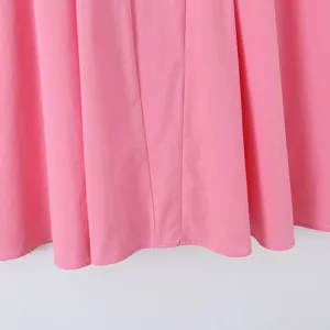 Rosa Kleid Stoff Detail, vertikale Nählinien, plissierte Saum Textur Nahaufnahme.
