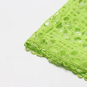 Tissu de robe en broderie de dentelle vert lime montrant des détails ajourés au crochet.