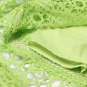 Gros plan sur les détails de la robe en dentelle verte ajourée et sa doublure douce.