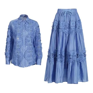 Detalle camisa manga larga bordado encaje azul y falda larga con vuelo, conjunto elegante.