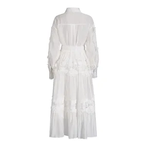 Elegante vestido camisa blanco de manga larga con bordado delicado y falda con volantes.
