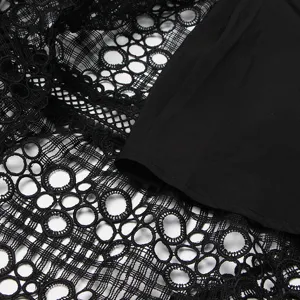 Détail de robe brodée creuse en dentelle noire, texture de tissu de mode élégante.