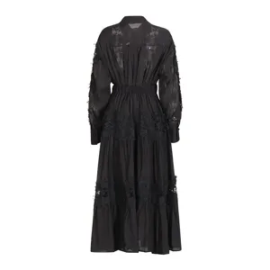 Vista trasera del vestido negro de manga larga con detalles de bordado de encaje calado.
