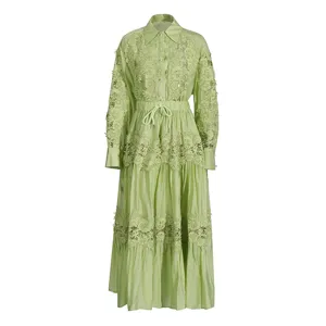 Detalle de conjunto de camisa falda verde con encaje bordado calado y delicados motivos.