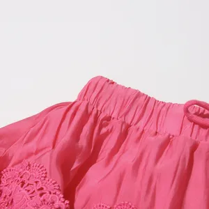 Detalle de primer plano de la cintura elastica y los bordados de encaje de la falda rosa.