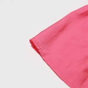 Primer plano de tela rosa que muestra costuras finas y precisas, foto de estudio limpia.