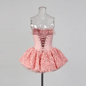 Mini-robe corset rose sans bretelles avec lacets, détail de jupe en pétales de rose à volants.