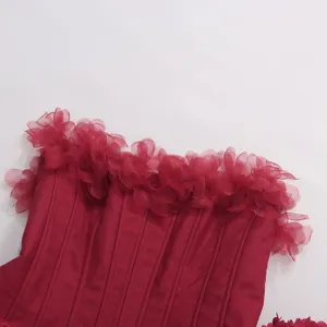 Détail de haut corset sans bretelles rouge montrant un design de volants en organza.