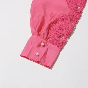 Detalle de manga de camisa bordada de encaje rosa con botones de perlas, primer plano moda.