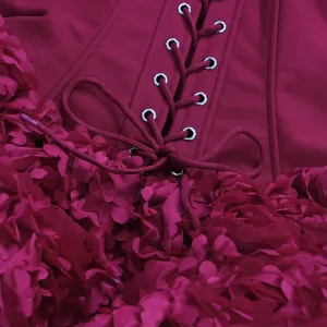 Détail de robe bustier corset bordeaux, avec œillets métalliques et délicates applications florales.