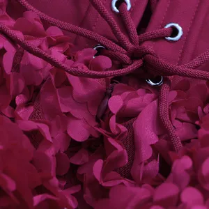 Détail en gros plan de robe vintage rouge foncé avec pétales mesh et laçage corset.