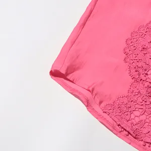 Vista detallada en primer plano de camisa de verano rosa para mujer con bordado de encaje.