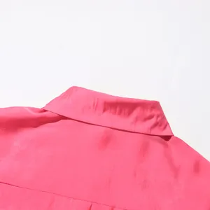 Vista en detalle del cuello de la camisa rosa, mostrando tela fina y costuras en la espalda.