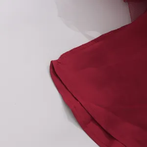 Vue rapprochée détaillée de l'ourlet de la mini-robe rouge foncé avec tulle blanc.