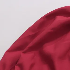 Gros plan détaillé de la texture de tissu rouge vif, surface lisse et beau tombé pour robe.