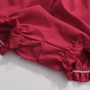Gros plan détaillé de la robe bouffante vintage rouge vif, montrant de superbes volants.