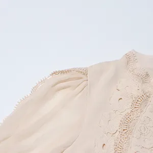 Gros-plan sur la robe longue beige élégante avec broderie de dentelle florale complexe.